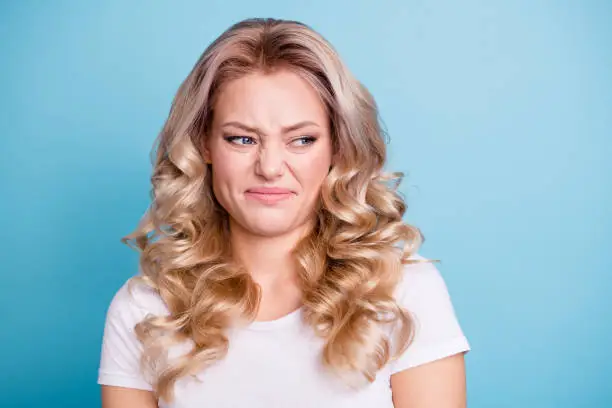 Close up photo beautiful her she lady awful awkward situation look hate mad rage outraged ugh facial expression wear casual white t-shirt jeans denim clothes outfit isolated bright blue background.