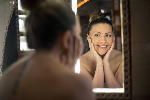 istock Young woman looking in the mirror 1141182573