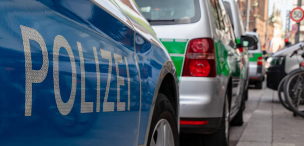 blau-grün deutsche polizeiautos parken in einer reihe am hauptbahnhof in münchen, wegen eines fußballspiels - football police officer crowd stock-fotos und bilder