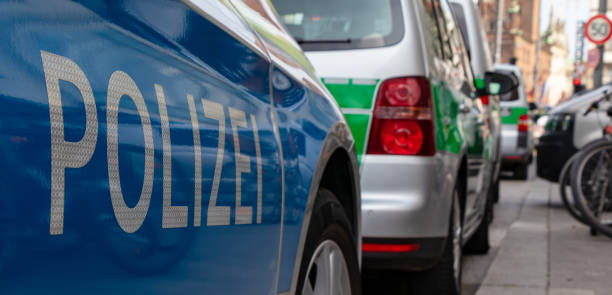 bleu et vert allemand voitures de police parking dans une rangée à la gare centrale de munich, à cause d’un match de football - football police officer crowd photos et images de collection