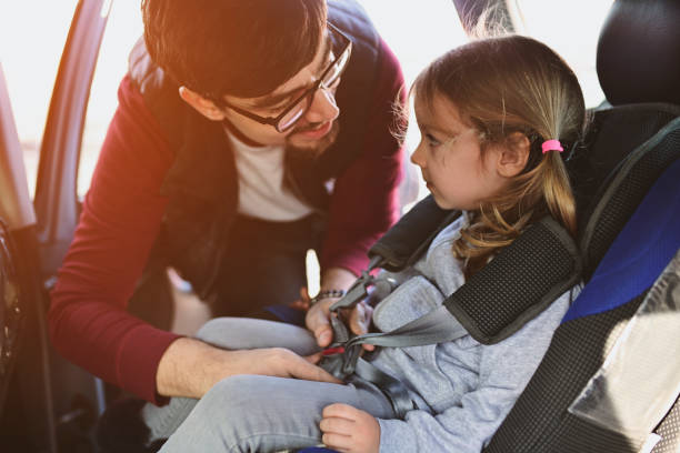 istock Safety first, father puts child in car seat 1141182794