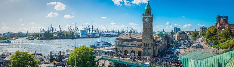 Panoramic view across the busy walkways and waterfront of Landungsbrucken, the ferry harbour and the Elbtunnel at St. Pauli, Hamburg, Germany.