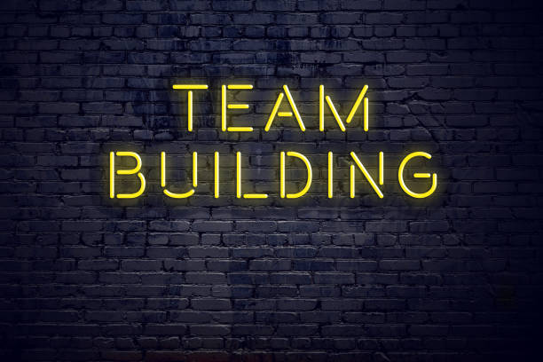 istock Night view of neon sign with text team building 1141184408