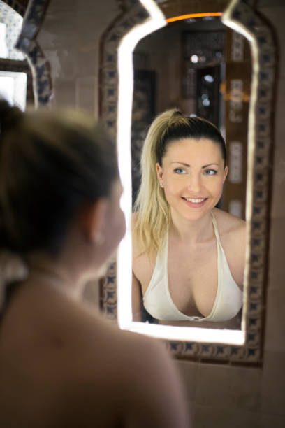 istock Beautiful woman looking in a mirror 1141185198