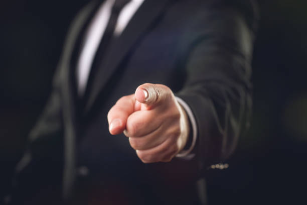 Businessman on Dark Background Pointing His Finger