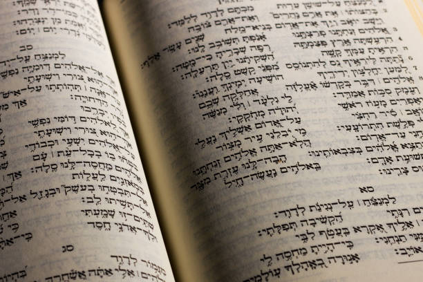 istock Alicante, Spain - April 2019: Open hebrew Bible, isolated on black background, with side lighting 1141195718