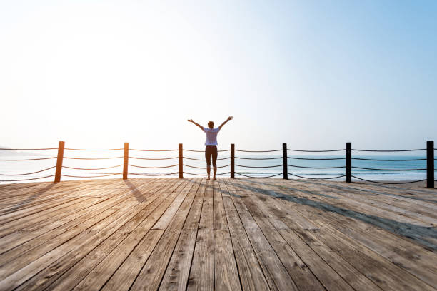 istock Woman standing on boardwalk at the beach 1141196011