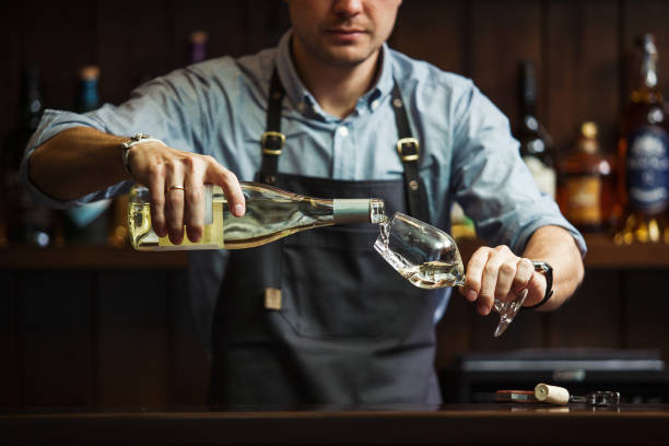 samiec sommelier wlewa białe wino do długo łodygi kieliszki do wina. - wine pouring wineglass white wine zdjęcia i obrazy z banku zdjęć