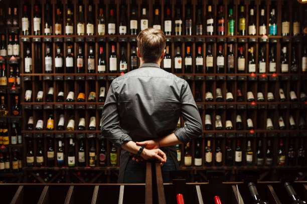 barman à wine cave plein de bouteilles avec des boissons exquises - cellar photos et images de collection