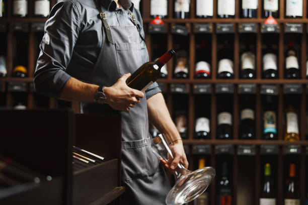 istock Bartender holds bottle of wine and unusual glass vessel 1141197929