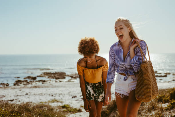 istock Two happy women walking along the beach 1141197990