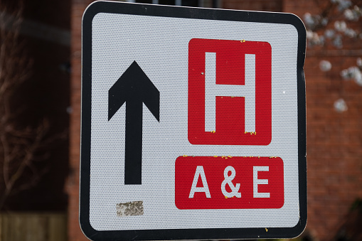 Road sign indicating the direction to a hospital with an A&E department