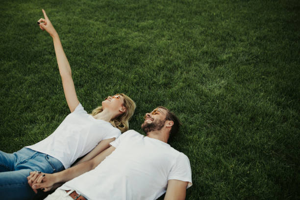 istock Cheerful young couple having rest on green grass 1141201427