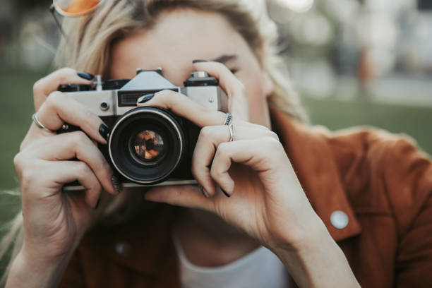 istock Close up of camera in female hands 1141201433