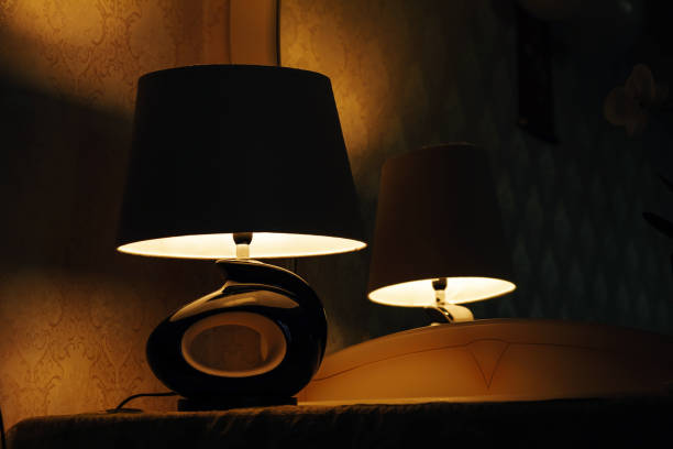 istock Lamp on a night table next to a bed 1141202586