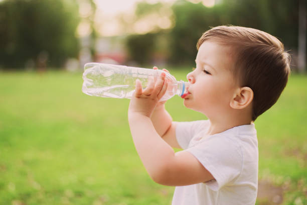 istock handsome boy drinks clear water from a bottle on a sunny day outside 1141206421