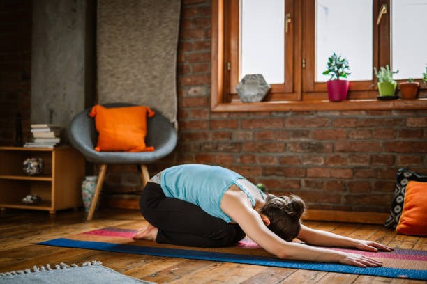 istock Woman Practicing Yoga - Child Pose 1141207017