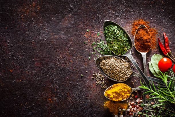 istock Spices and herbs in vintage spoons shot from above on rustic brown table 1141208063