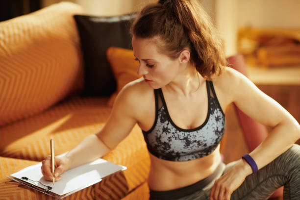 istock fit woman with diary and pen building workout schedule 1141208132