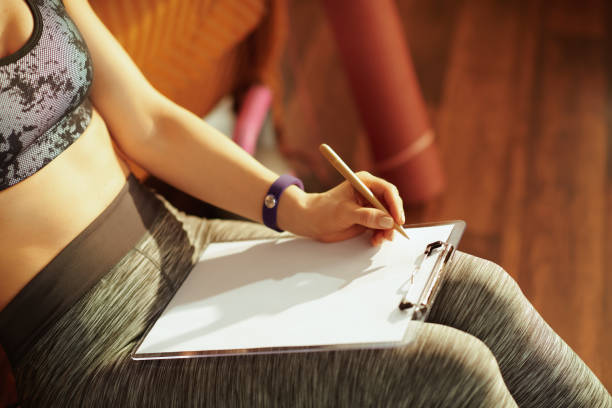 istock Closeup on woman with clipboard and pen writing training log 1141208167