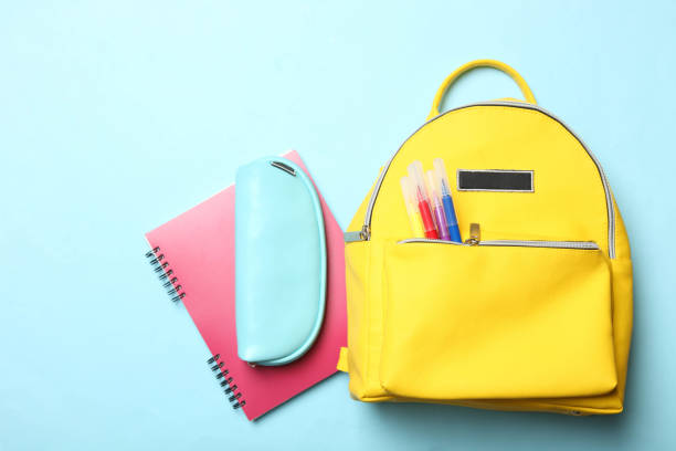istock yellow backpack with different school supplies 1141208568