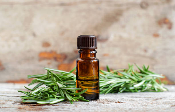 piccola bottiglia di olio essenziale di rosmarino sul vecchio sfondo di legno. ingredienti aromaterapica, termale ed erboristeria. copiare lo spazio. - alternative therapy immagine foto e immagini stock