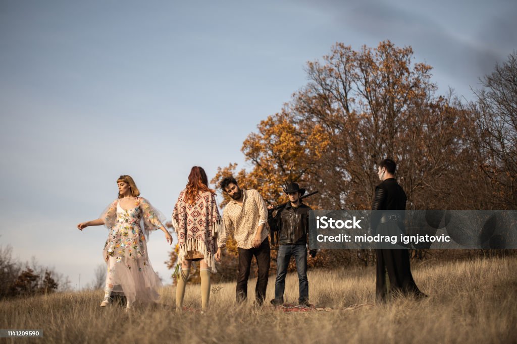 Group of weird people on meadow Group of young,  weird people dancing on meadow on beautiful day Dancing Stock Photo