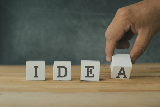 istock Creative and success concept, hand  putting wood cube block with word idea on wooden table. 1141209794