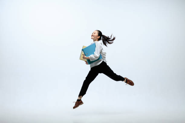 オフィスで働く女性とスタジオの背景に孤立ジャンプ - jumping business women dancing ストックフォトと画像