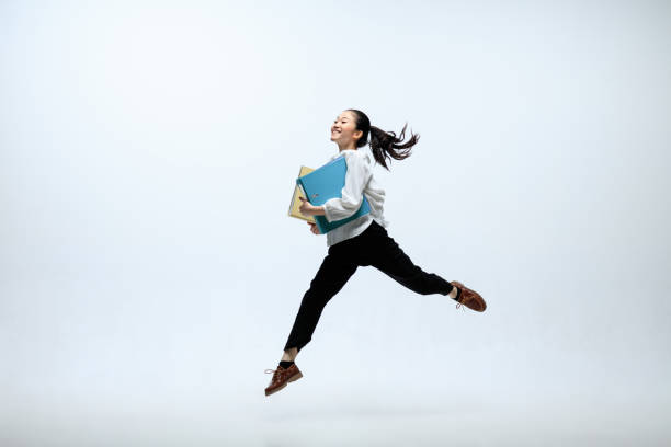 istock Woman working at office and jumping isolated on studio background 1141209961