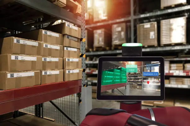 Industrial 4.0 , Augmented reality and smart logistic concept. Robot adviser with AR application for check order pick time in smart factory industry warehouse.