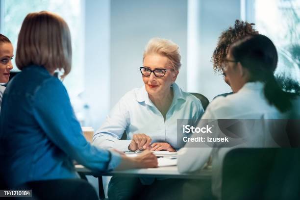 Businesswomen Having Meeting At Desk In Office Stock Photo - Download Image Now - Businesswoman, Mature Adult, 35-39 Years