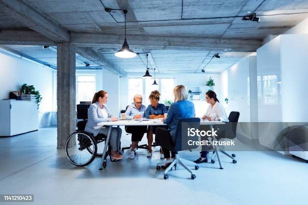 Female Entrepreneurs Having Meeting In New Office Stock Photo - Download Image Now - Wheelchair, Working, Disability