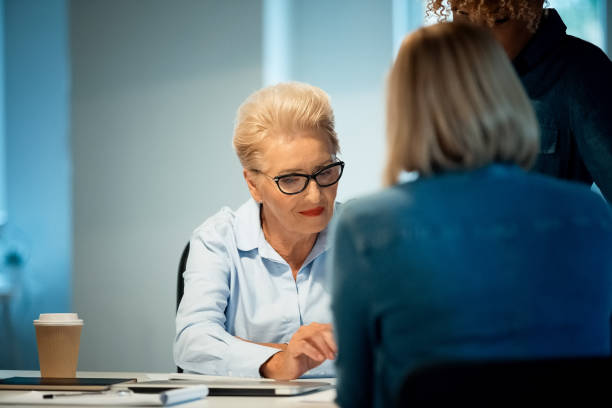 istock Senior woman working with colleagues in new office 1141211048