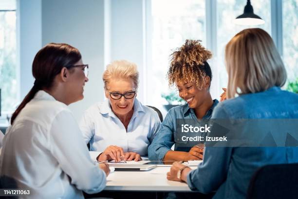 Smiling Businesswomen Working In New Office Stock Photo - Download Image Now - 35-39 Years, 40-44 Years, 70-79 Years