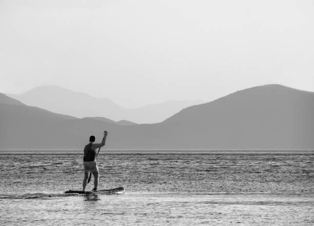 Island of Evia, Greece. July 2018:  SUP Surfing at sunset in the Aegean Sea