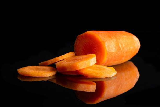 istock Fresh orange carrot isolated on black glass 1141211567