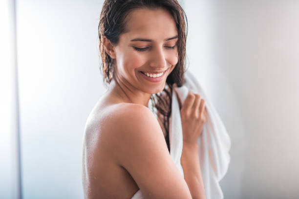 istock Smiling female wrapping in fluffy towel 1141213156