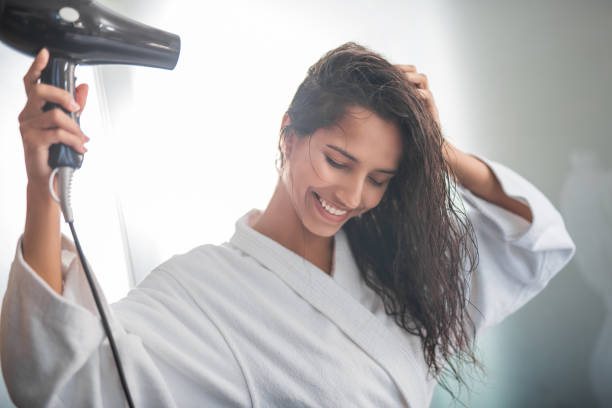 istock Happy lady drying hair with equipment 1141213173
