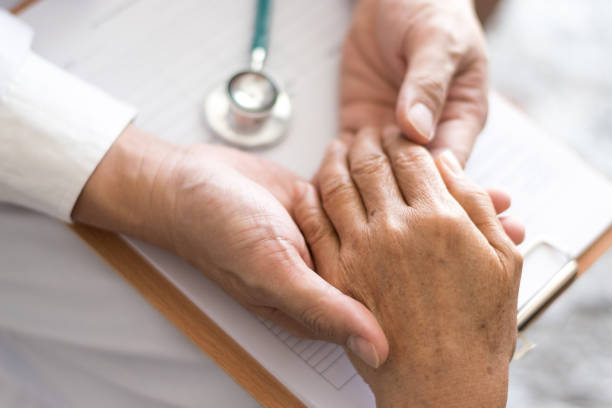parkinson und alzheimer senioren-patientinnen halten hand beim arzt in hospizbetreuung. konzept der medizinischen versorgung - 40 weeks stock-fotos und bilder