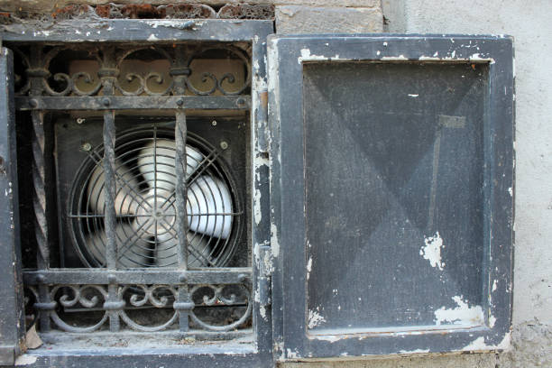 Old window of a basement with a new metal ventilator