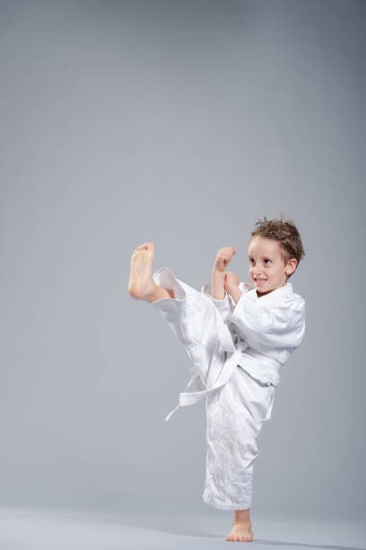 Child having fun performing karate kata while practicing a sport they like.