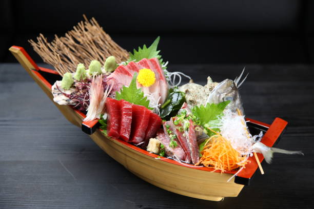 seasonal sashimi boat seasonal sashimi boat on a dinibg table acanthuridae photos stock pictures, royalty-free photos & images