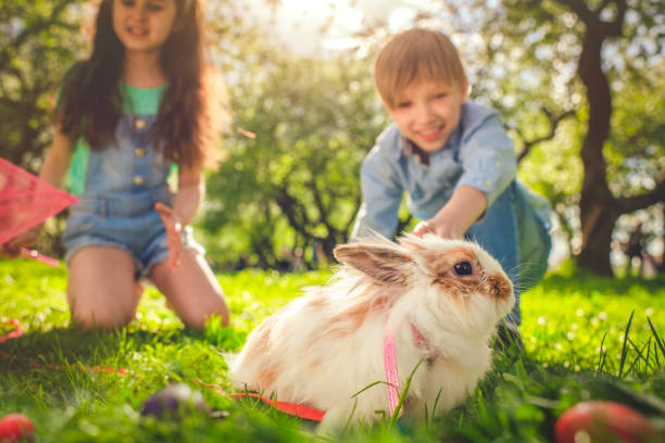 istock Happy children playing with bunny on Easter egg hunt 1141222840