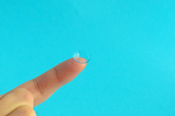 istock contact lens on finger on lblue background. 1141224801