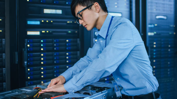 istock In the Modern Data Center: IT Technician Working with Server Racks, on a Pushcart Installing New Hardware. Engineer Doing Maintenance and Diagnostics of the Database. 1141224905