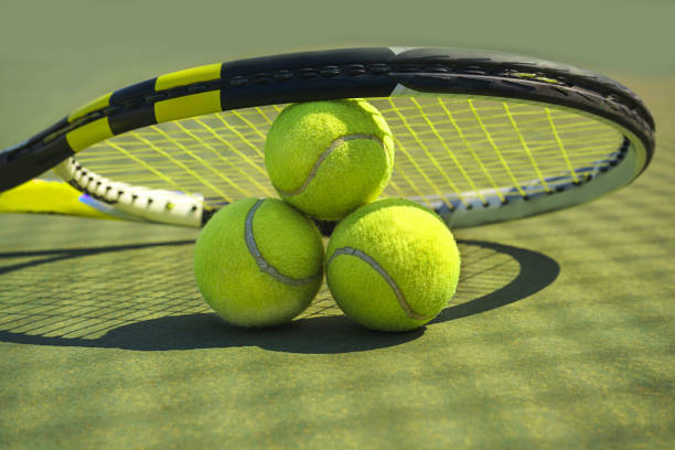 芝コートでテニスボールとラケット。 - tennis court action toughness ストックフォトと画像