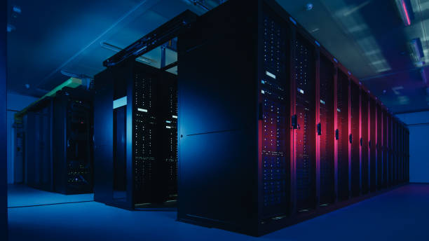 istock Shot of Data Center With Multiple Rows of Fully Operational Server Racks. Modern Telecommunications, Cloud Computing, Artificial Intelligence, Database, Supercomputer Technology Concept. Shot in Dark with Neon Blue, Pink Lights. 1141225056