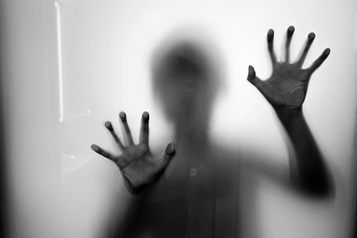 A woman trapping behind frosted glass.