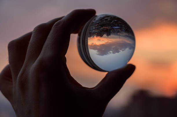 istock Glass ball which reflects sunset sky over city. 1141226029